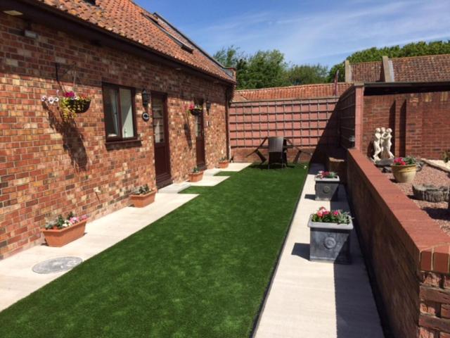 a courtyard of a brick building with green grass at 3 Bed in Brean MAINC in Berrow