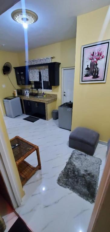 a living room with a room with a white floor at Finest Accommodation #528 Stem Ave Jacaranda 1 bedroom in Spanish Town
