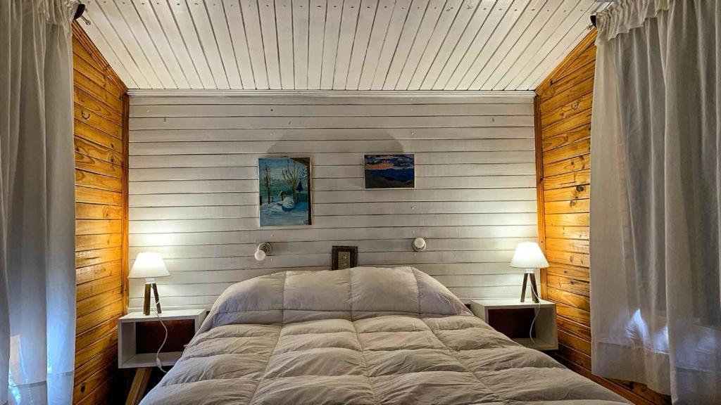 1 dormitorio con 1 cama grande y 2 mesitas de noche en Fiordo B&B and Beer-Spa en Potrerillos