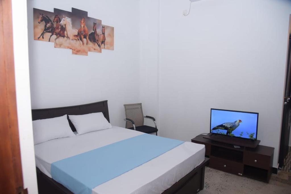 una camera con letto e TV su un tavolo di lotuscool hotel a Kurunegala