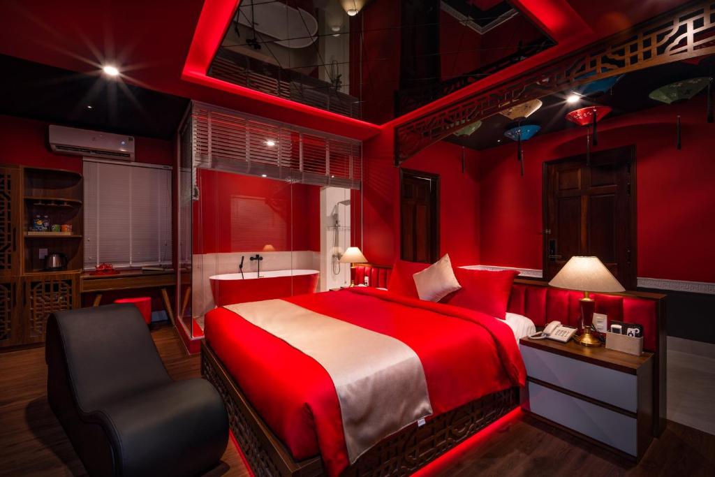 una camera da letto rossa con un letto e una sedia di Chiic House 4 - Khách sạn tình yêu a Quy Nhon