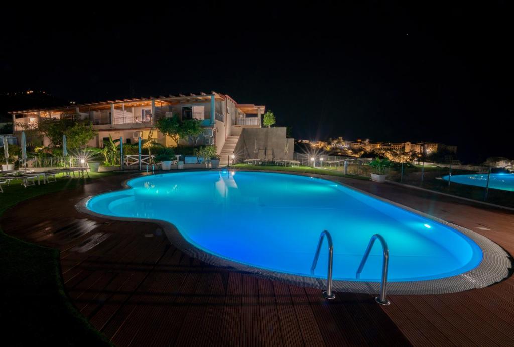 een groot blauw zwembad 's nachts bij Residence New Paradise in Tropea