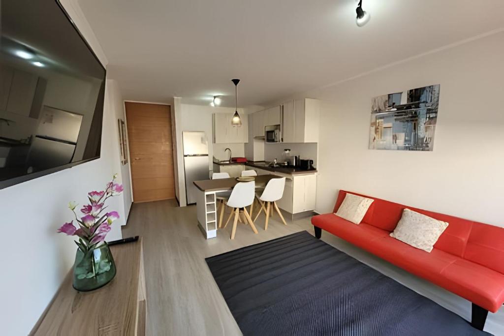 ein Wohnzimmer mit einem roten Sofa und einer Küche in der Unterkunft Condominio Pacífico 3100 in La Serena