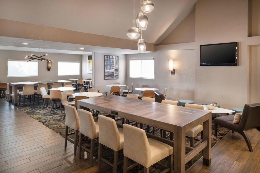 長灘的住宿－Residence Inn by Marriott Long Beach，用餐室配有桌椅和平面电视。