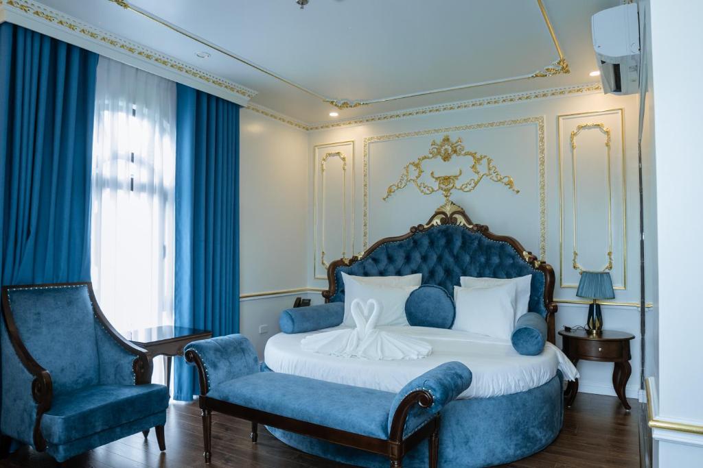 a bedroom with a blue bed and a blue chair at Royal Dương Nội Hotel in Hanoi