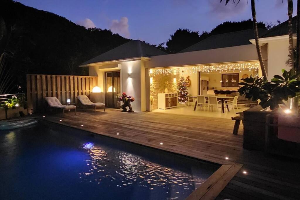 een achtertuin met een zwembad en een houten terras bij Villa JELO - 2 Suites 2.5 Sdb Piscine & SPA* * * * in Saint Barthelemy
