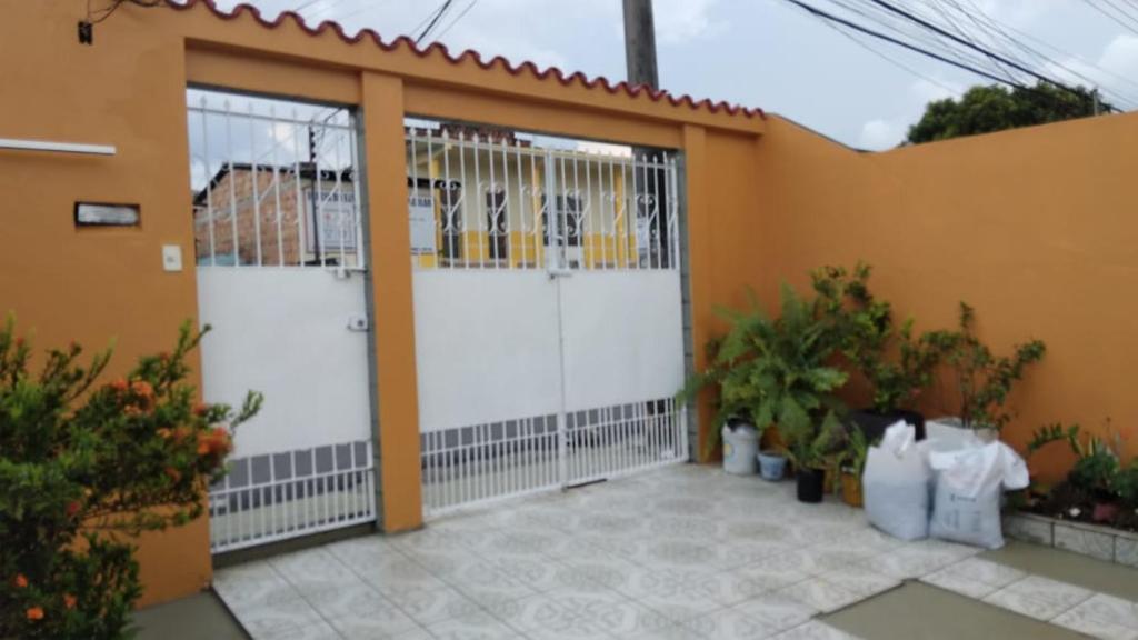 a garage with two white doors and some plants at Casa Edgar in Manaus