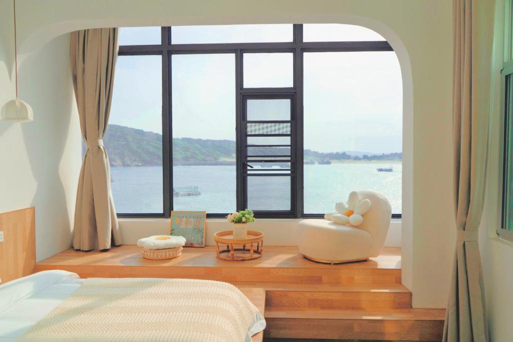 a bedroom with a large window overlooking the water at 一抹云海景民宿 in Pingtan