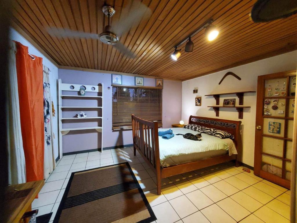 - une chambre avec un lit et un plafond en bois dans l'établissement Boho Farm Villa, à Tarzali