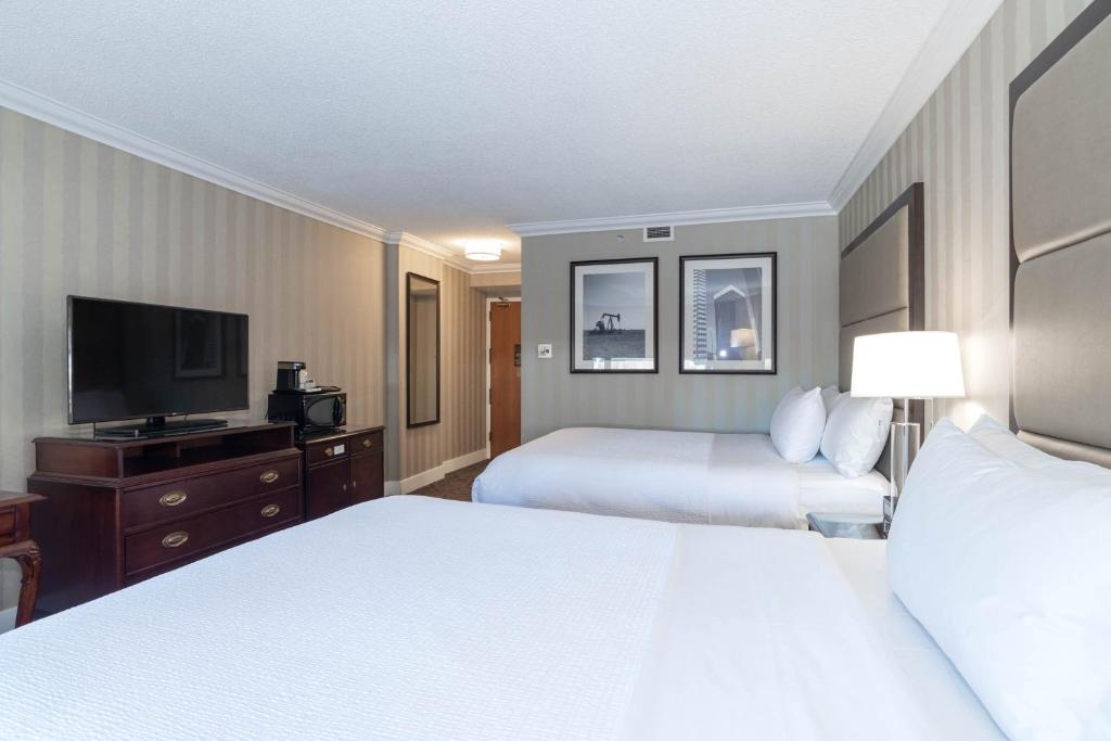 a hotel room with two beds and a flat screen tv at Sandman Signature Edmonton Downtown Hotel in Edmonton