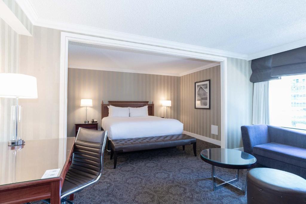 a hotel room with a bed and a couch at Sandman Signature Edmonton Downtown Hotel in Edmonton