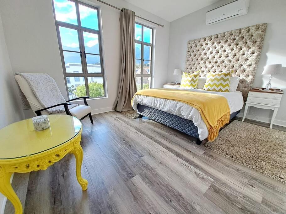 a bedroom with a bed and a yellow table at 700m From Franschhoek Center in Franschhoek
