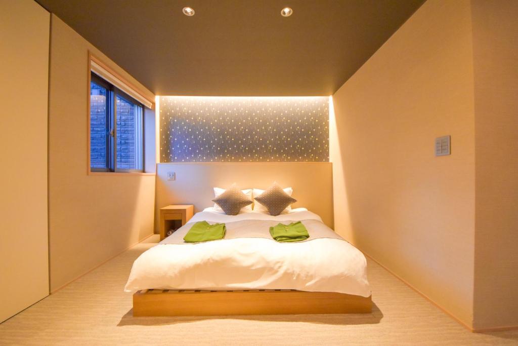 1 dormitorio con 1 cama blanca y ventana en Hotel Rokune, en Nara
