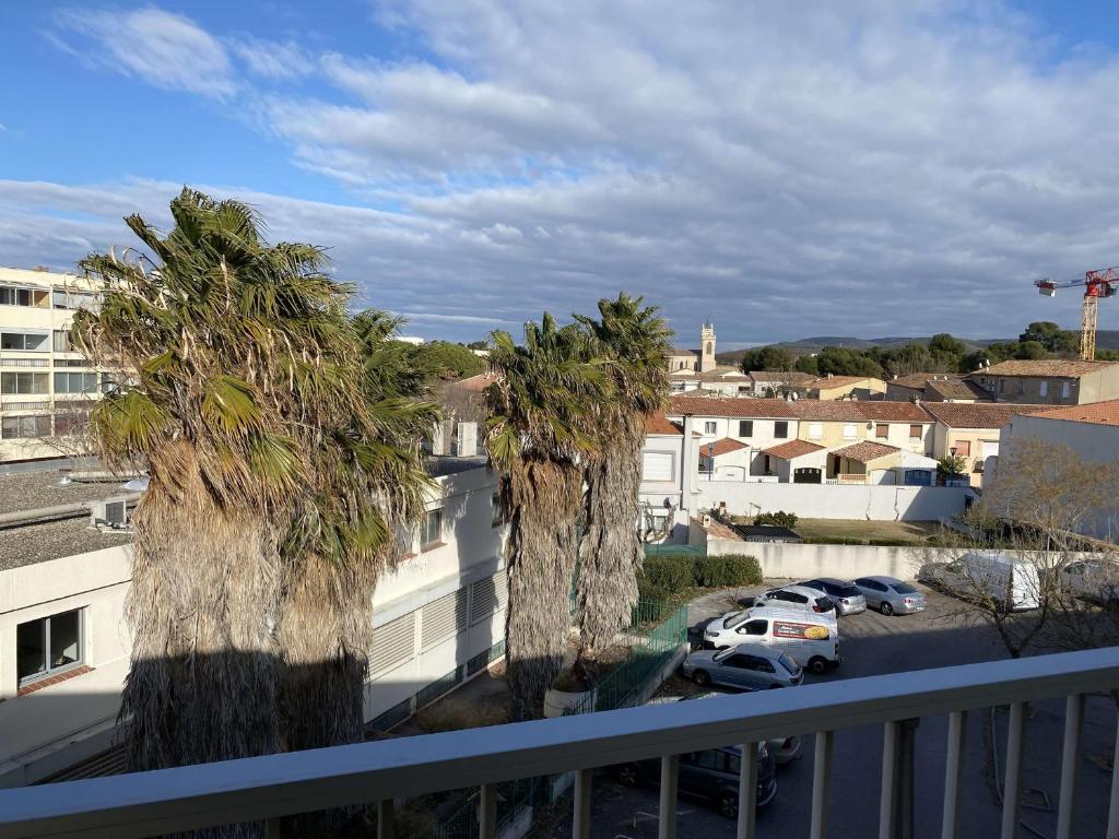- un balcon avec deux palmiers et un parking dans l'établissement Beau studio rénové 2 pers, climatisé, proche thermes, Parc Charles de Gaulle, balcon, 2 étoiles - FR-1-553-240, à Balaruc-les-Bains