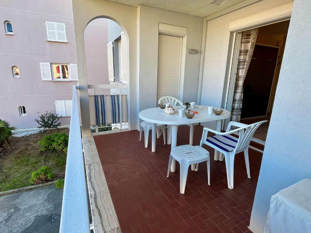 une table blanche et des chaises sur un balcon dans l'établissement Appartement Climatisé Proche Plage et Commerces - 2 Pièces, 4 Pers, Parking Privé, Animaux Acceptés - FR-1-226B-177, à Cavalaire-sur-Mer