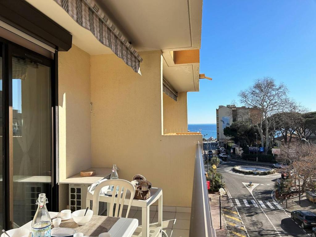 un balcon avec une table et des chaises et une vue sur l'océan dans l'établissement Appartement climatisé, 4 couchages, centre-ville du Lavandou, proche plage, parking inclus - FR-1-251-580, au Lavandou