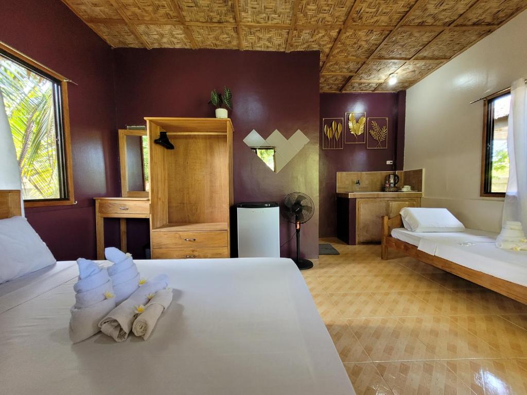 - une chambre avec un lit et des serviettes dans l'établissement Cecilia's Guest House, à Siquijor