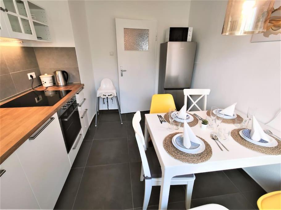 eine kleine Küche mit einem weißen Tisch und Stühlen in der Unterkunft Zwei Zimmer Wohnung Nähe Bahnhof in Karlsruhe