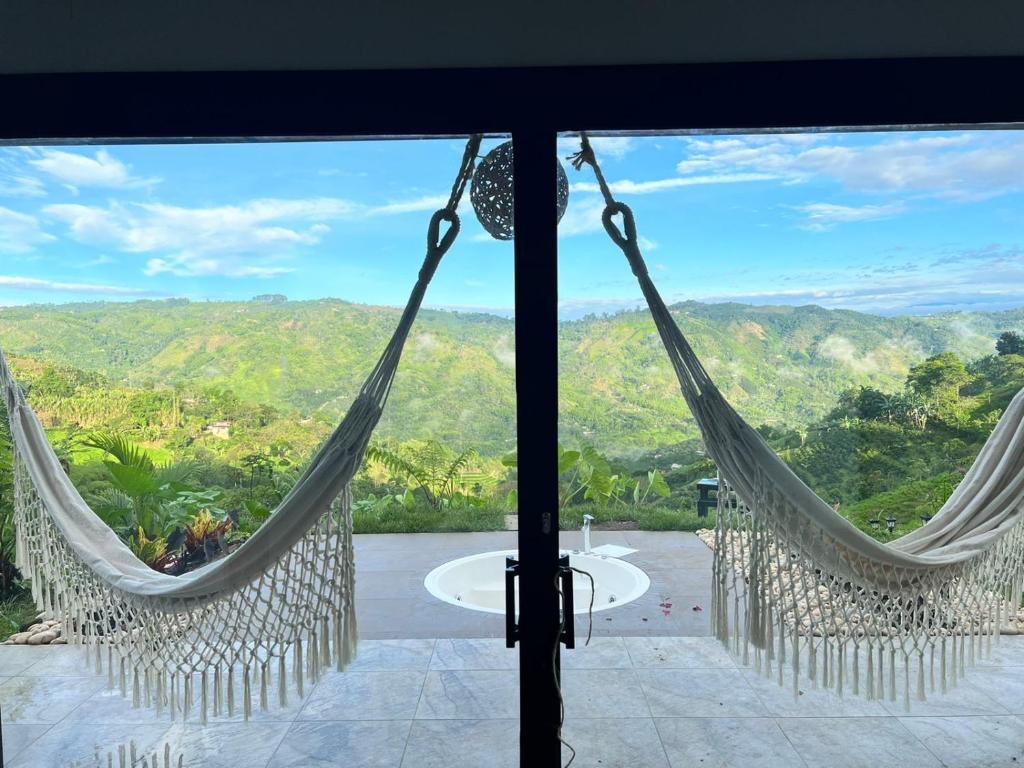 a view from the window of a room with hammocks at NABGUANA in Chinchiná
