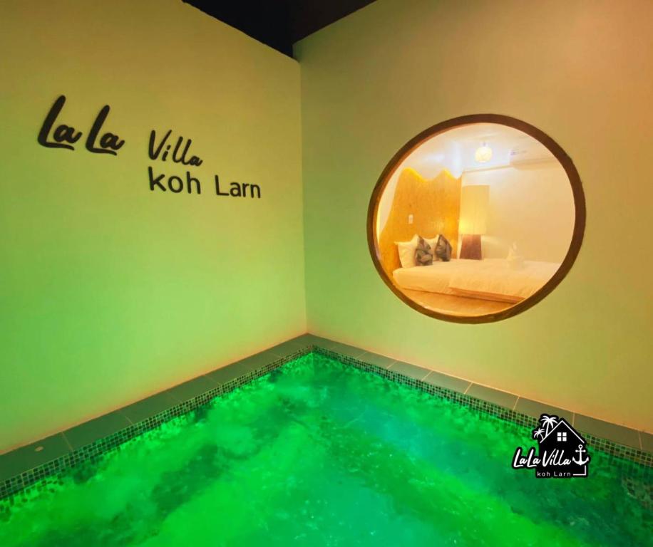 een zwembad in een kamer met een ronde spiegel bij Lala Villa Koh Larn in Ko Larn