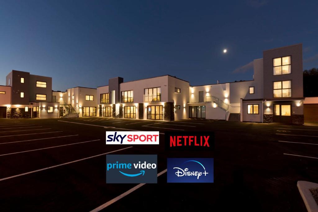 a building with a sky sport netflix sign in a parking lot at 2 on Whiteleigh and 239 on Lincoln Motel in Christchurch