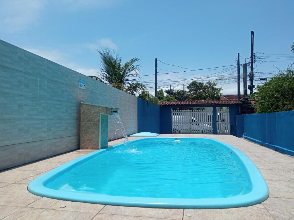 une grande piscine bleue dans une arrière-cour dans l'établissement Casa em Mongaguá, próximo a Plataforma de Pesca, à Mongaguá