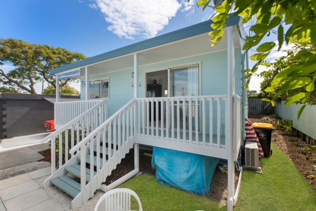 a mobile home with a porch and stairs at Omanu Cottage in Mount Maunganui
