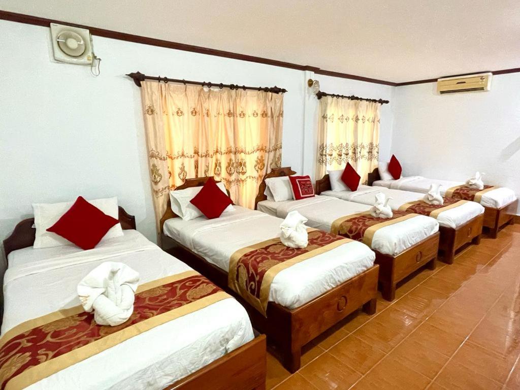 Un grupo de 4 camas en una habitación en SISAVANG HOTEL, en Vang Vieng
