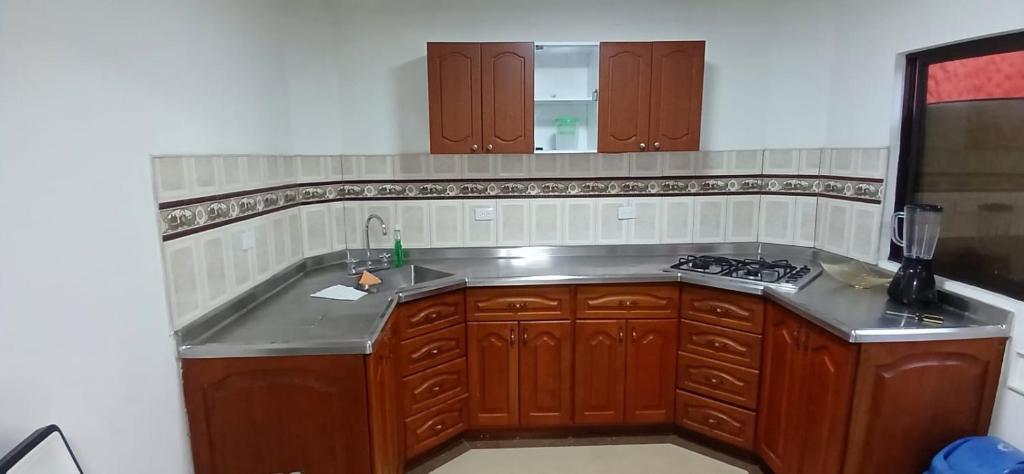 a kitchen with wooden cabinets and a sink at Apartamento Rionegro cerca al Aeropuerto in Rionegro