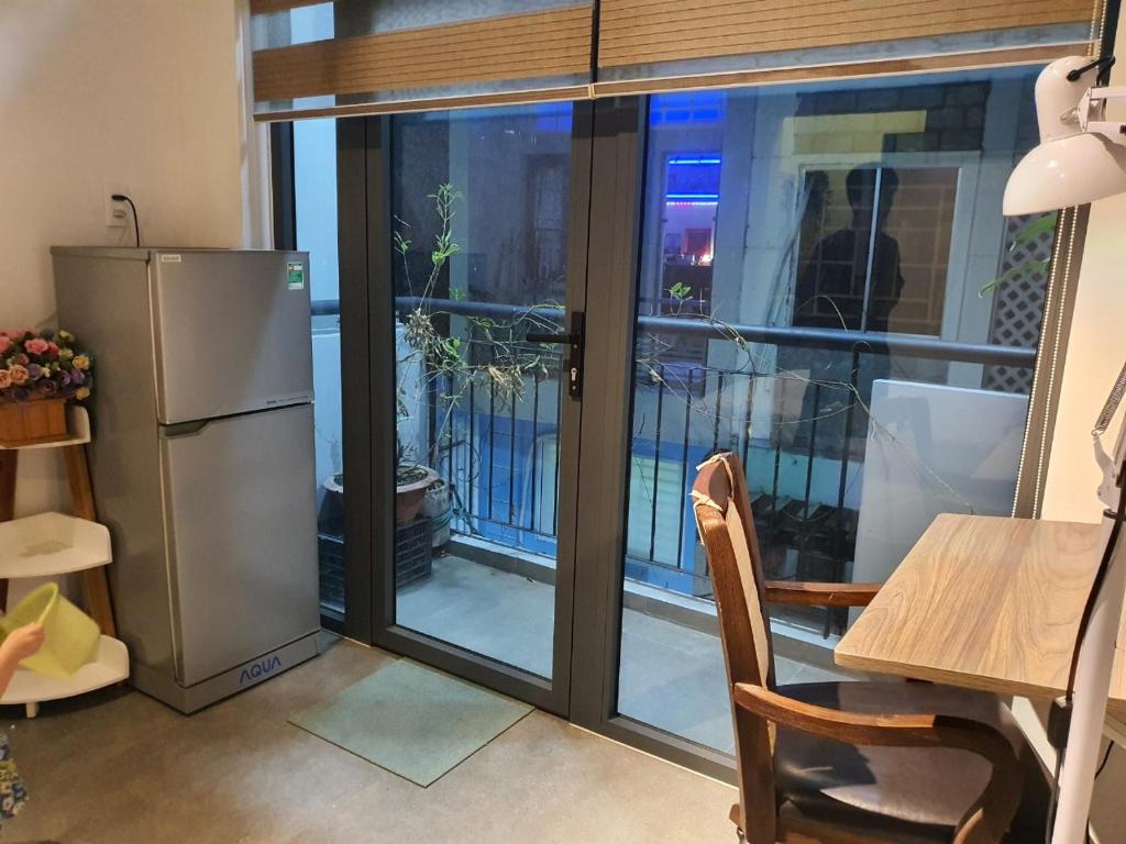 a kitchen with a sliding glass door with a table and a refrigerator at ZVillage NCC - Modern Townhouse in District 1 in Ho Chi Minh City