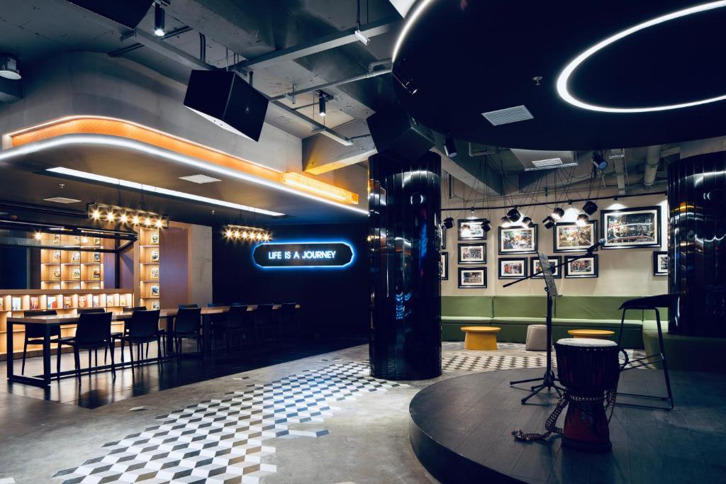 a restaurant with a bar with tables and chairs at Changsha Desti Youth Park Hostel in Changsha