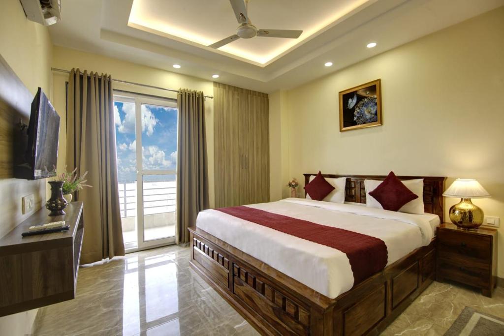 ein Schlafzimmer mit einem großen Bett und einem großen Fenster in der Unterkunft LIMEWOOD STAY SERVICE Apartment ARTEMIS HOSPITAL in Gurgaon