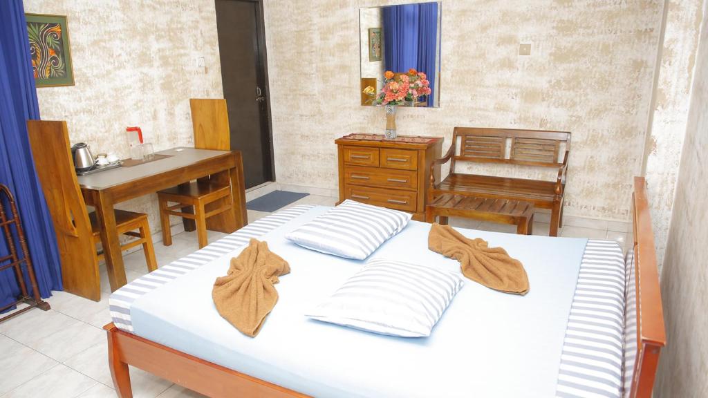 um quarto com uma cama, uma mesa e um lavatório em Hillstreet Villa em Dehiwala-Mount Lavinia