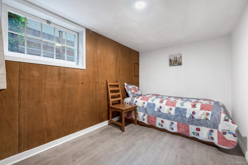 una camera con un letto e una sedia e una finestra di Deluxe Basement with Private Bedroom - R1 / R3 a Vancouver