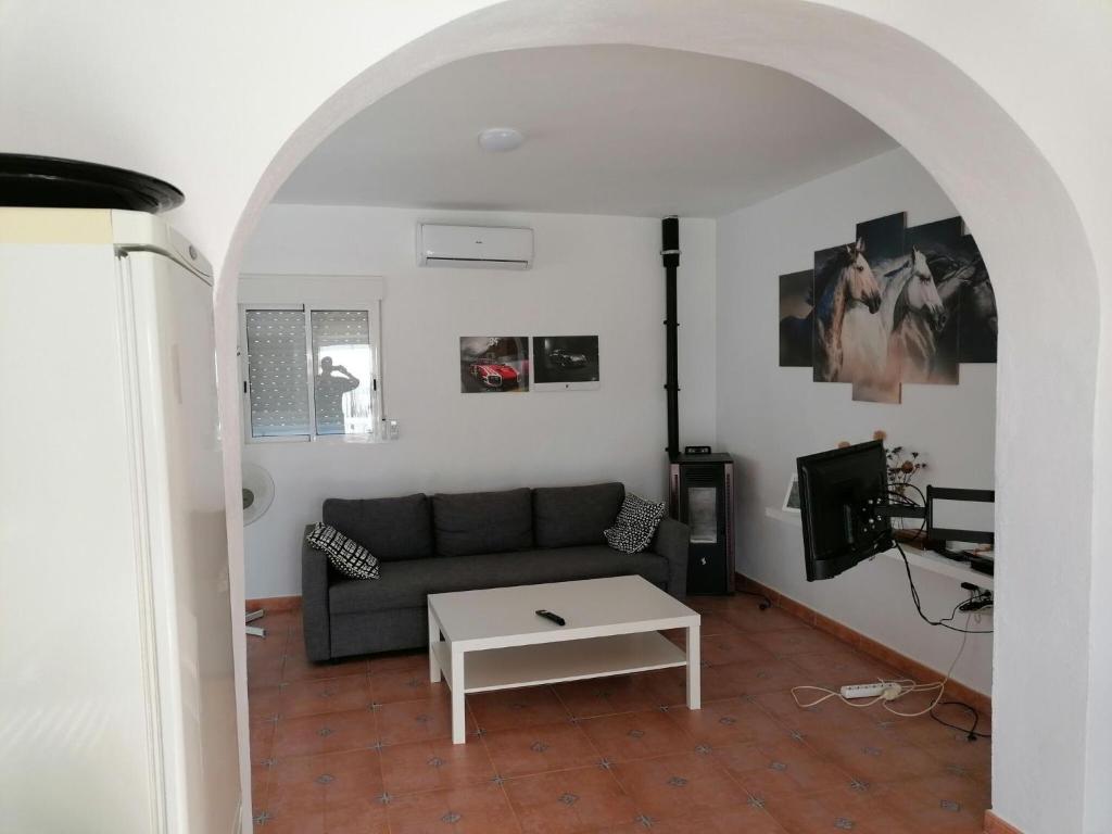 salon z kanapą i stołem w obiekcie Belvilla by Oyo Casa de Aguila w mieście Almogía