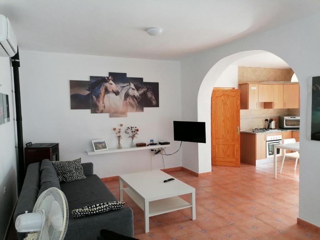 salon z kanapą i stołem w obiekcie Belvilla by Oyo Casa de Aguila w mieście Almogía