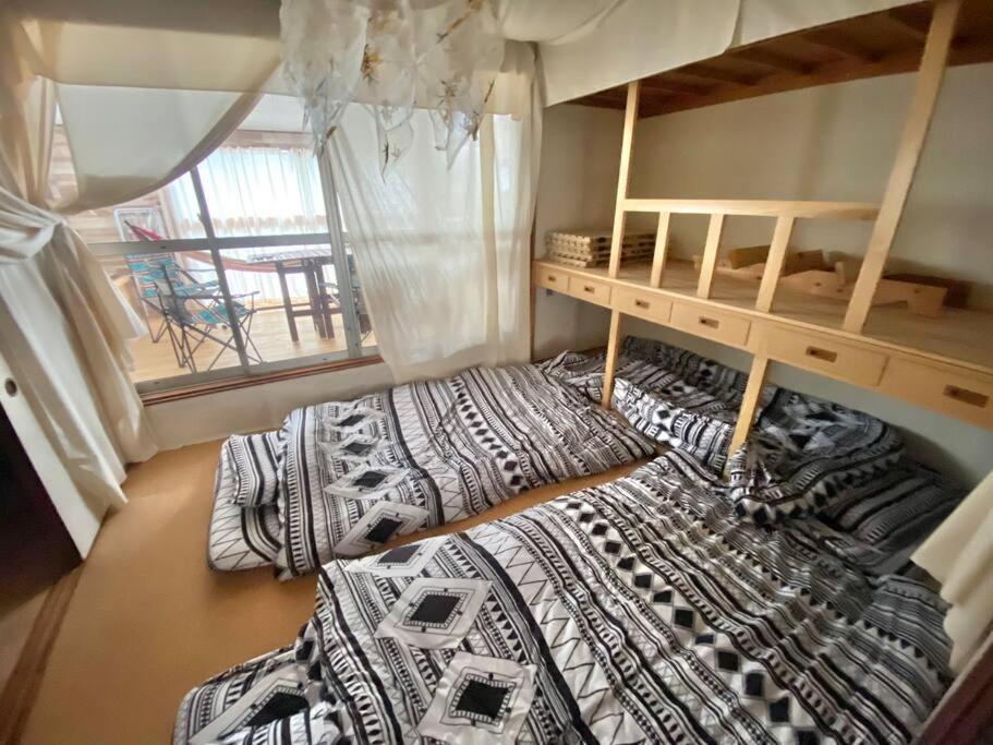 two bunk beds in a room with at 『沙羅居 レトロ&グランピング』名古屋駅徒歩10分の異空間 広々100 ㎡ 貸切古民家 最大11名様 in Chiharachō