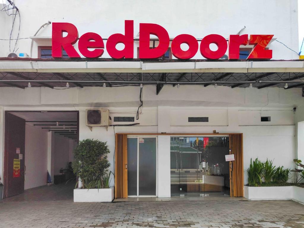 a red door sign on the side of a building at RedDoorz near Prambanan Temple in Klaten