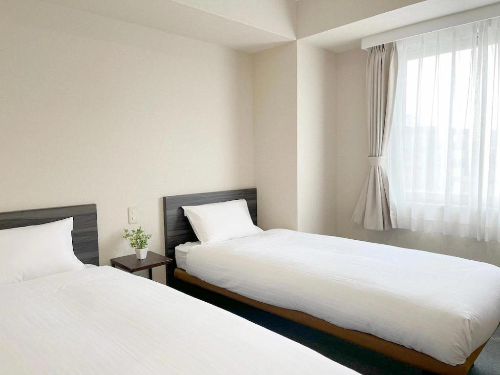 Postel nebo postele na pokoji v ubytování CHECKinn Osaka Shinimamiya
