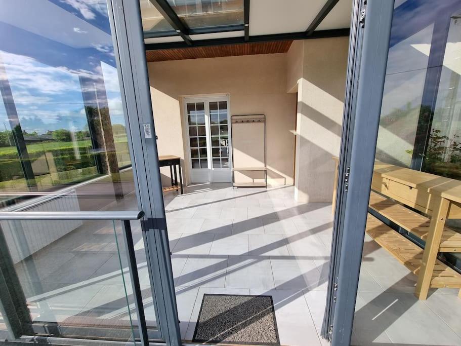- une vue depuis l'intérieur d'une maison avec une porte en verre dans l'établissement Maison chaleureuse en Normandie, à Habloville
