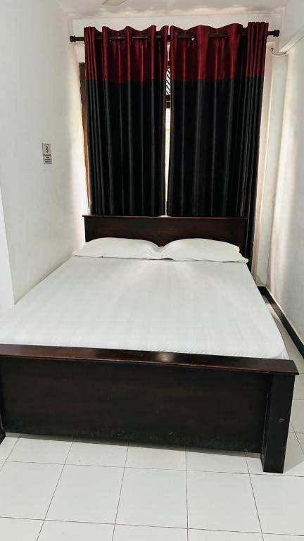 a bed in a room with a black curtain at Hotel Elephant Park in Kandy