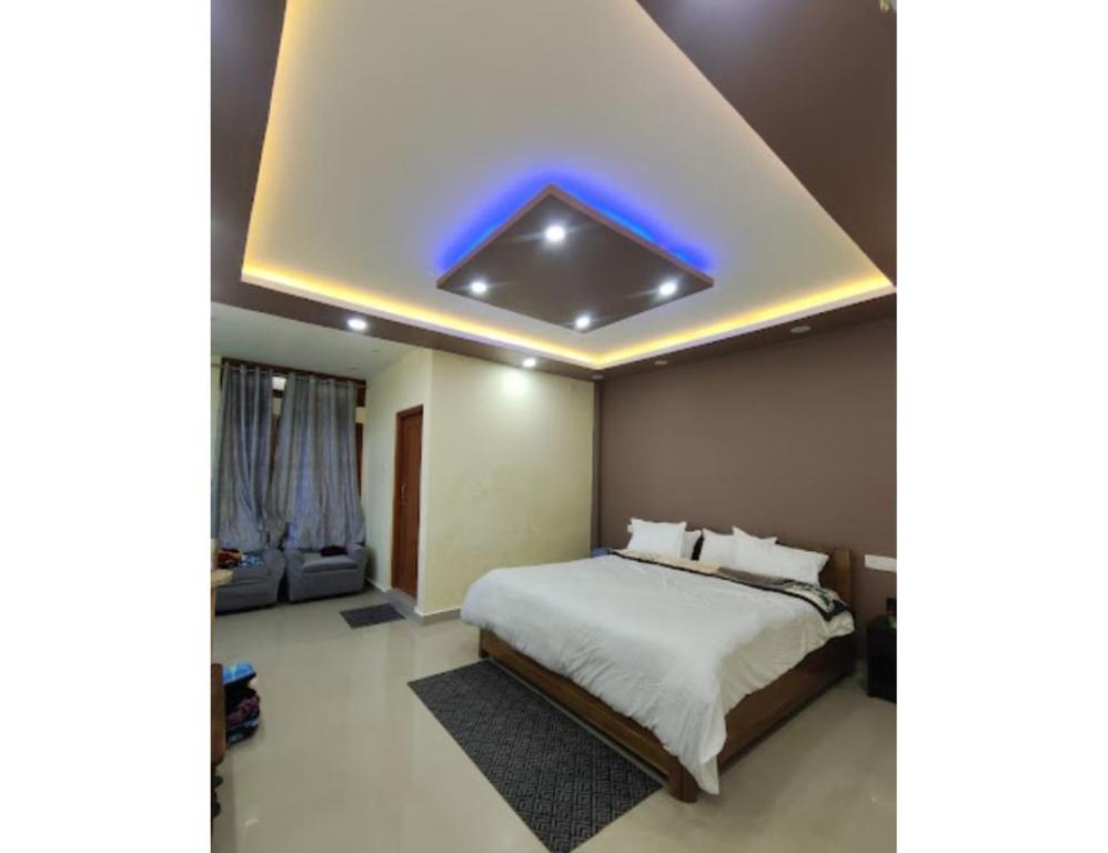een slaapkamer met een bed met een blauw licht aan het plafond bij Hotel Dawa Tawang, Arunachal Pradesh in Tawang
