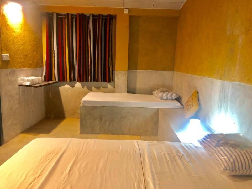 una camera con un letto e una panca di Himawwa Residency Pinnawala a Rambukkana