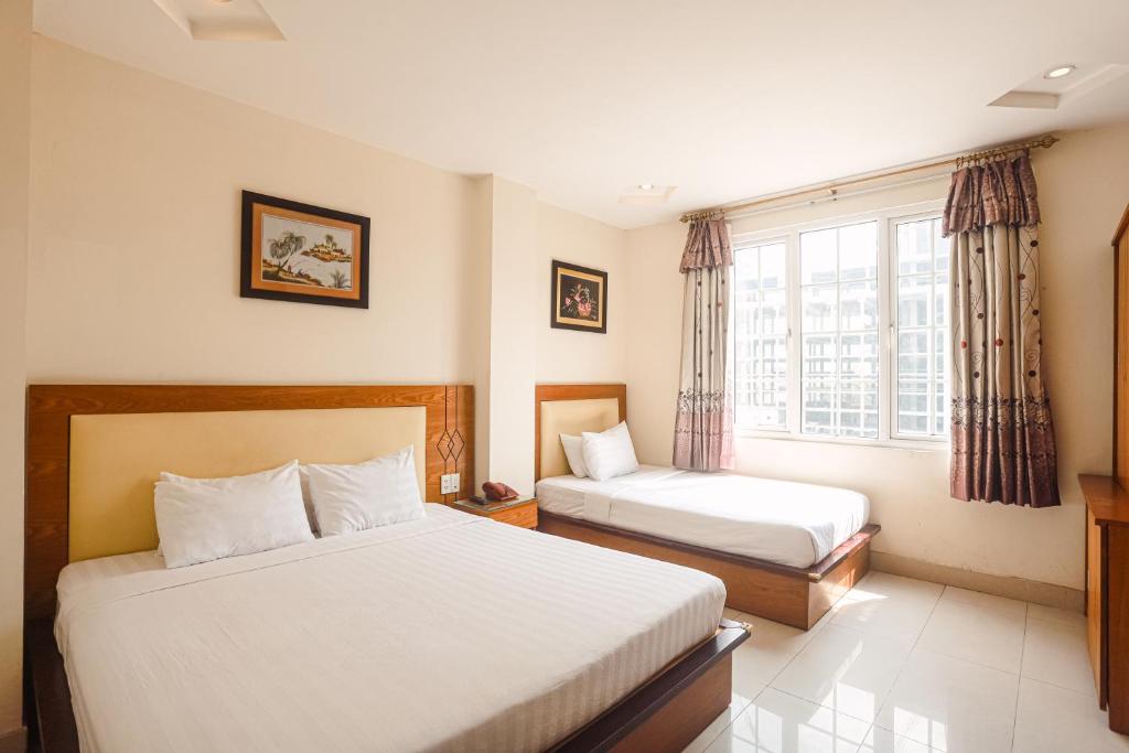 una camera d'albergo con due letti e una finestra di Song Anh 3 Hotel ad Ho Chi Minh