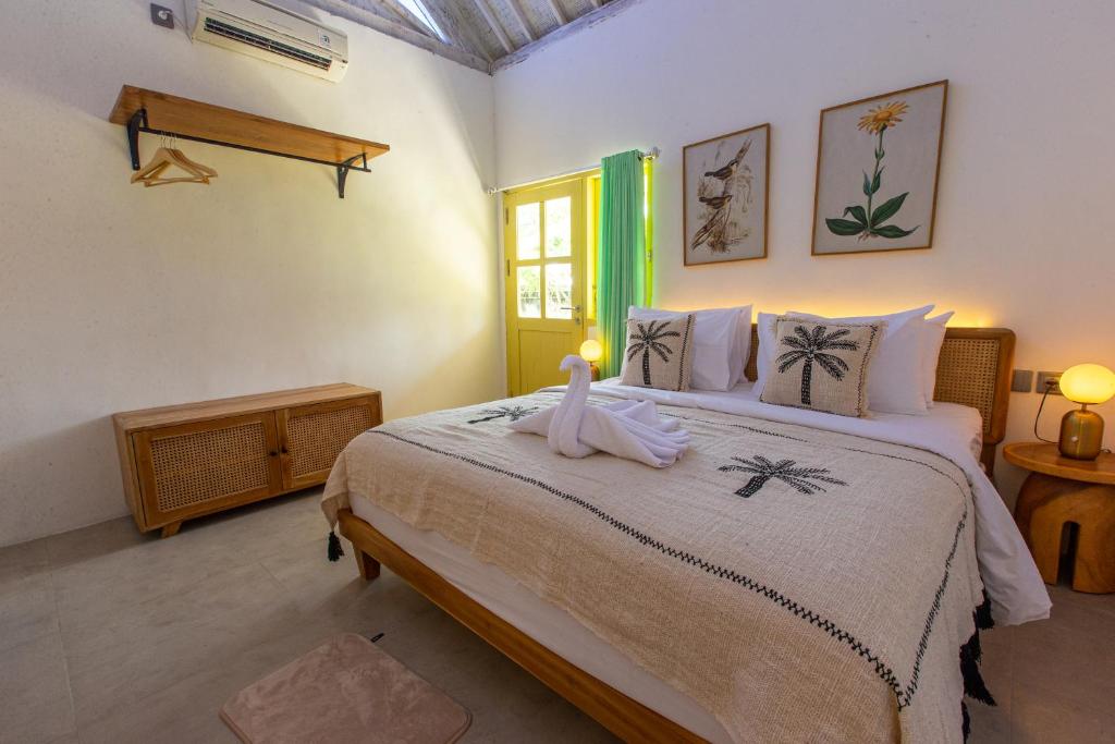 a bedroom with a bed with a towel on it at La Roja Bungalows in Nusa Penida