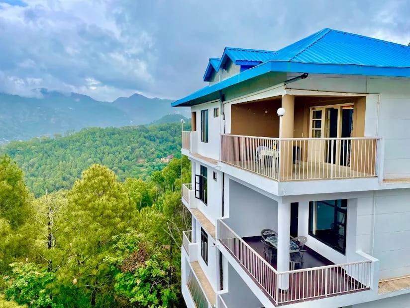 een huis met een blauw dak en een balkon bij The Terrace Retreat by StayVues in Kasauli
