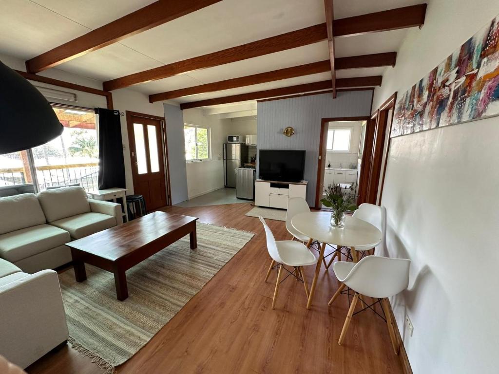 a living room with a table and a couch at By the Bay Beach Shack in Vincentia