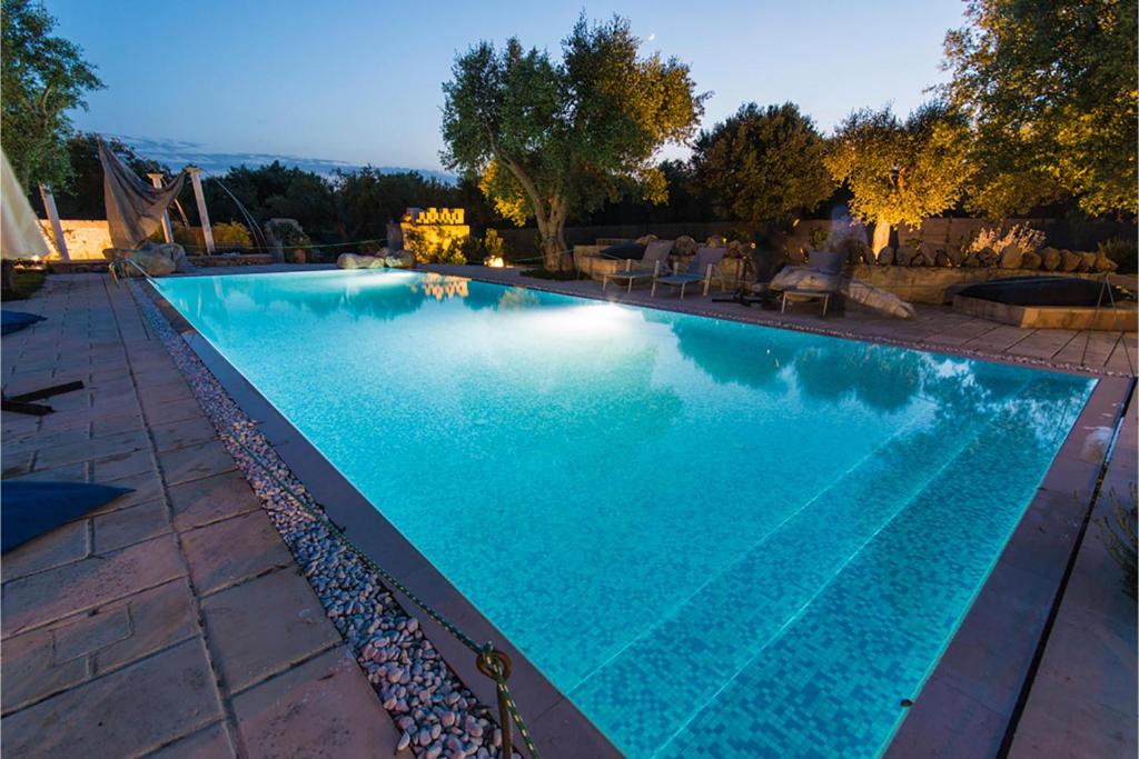 una gran piscina azul en un patio en Tenuta Bouganville With Garden And Pool - Happy Rentals, en Carpignano Salentino