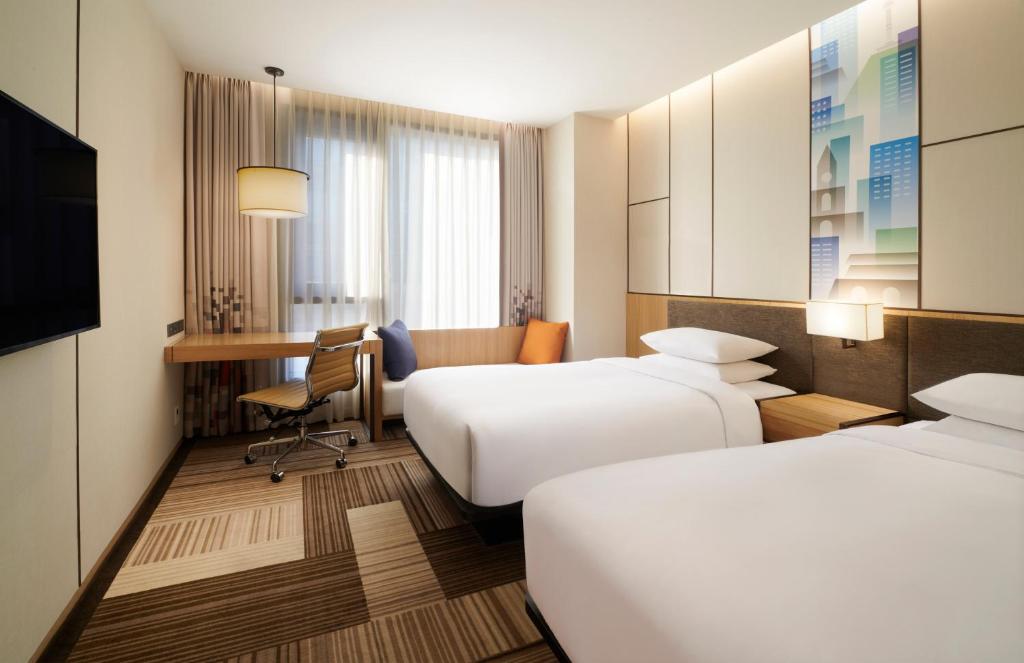 a hotel room with two beds and a desk at Aloft Seoul Myeongdong in Seoul