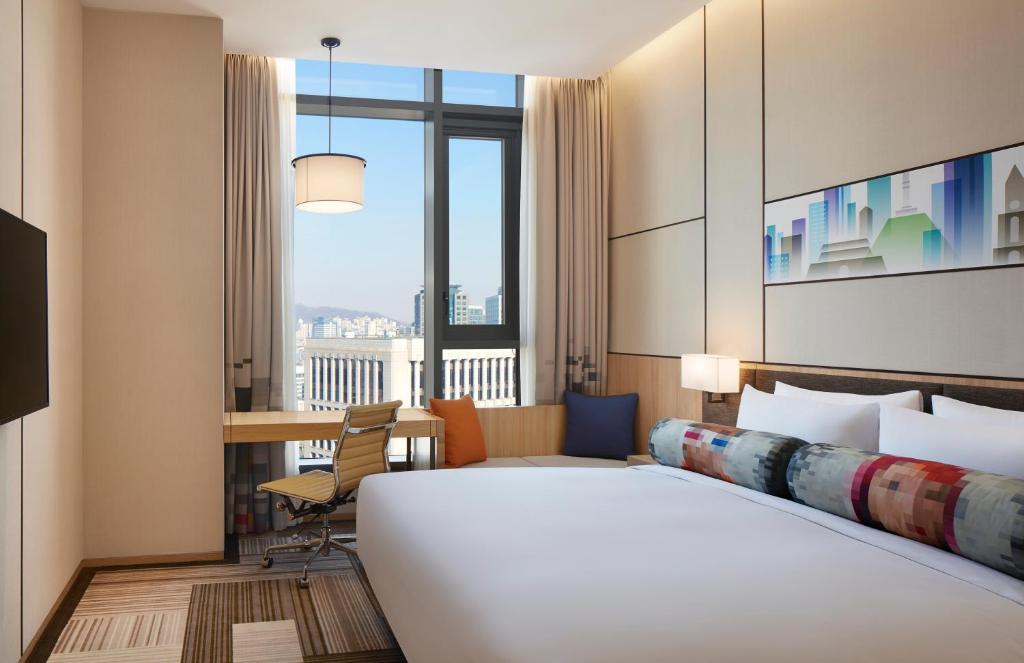 a hotel room with a bed and a desk at Aloft Seoul Myeongdong in Seoul